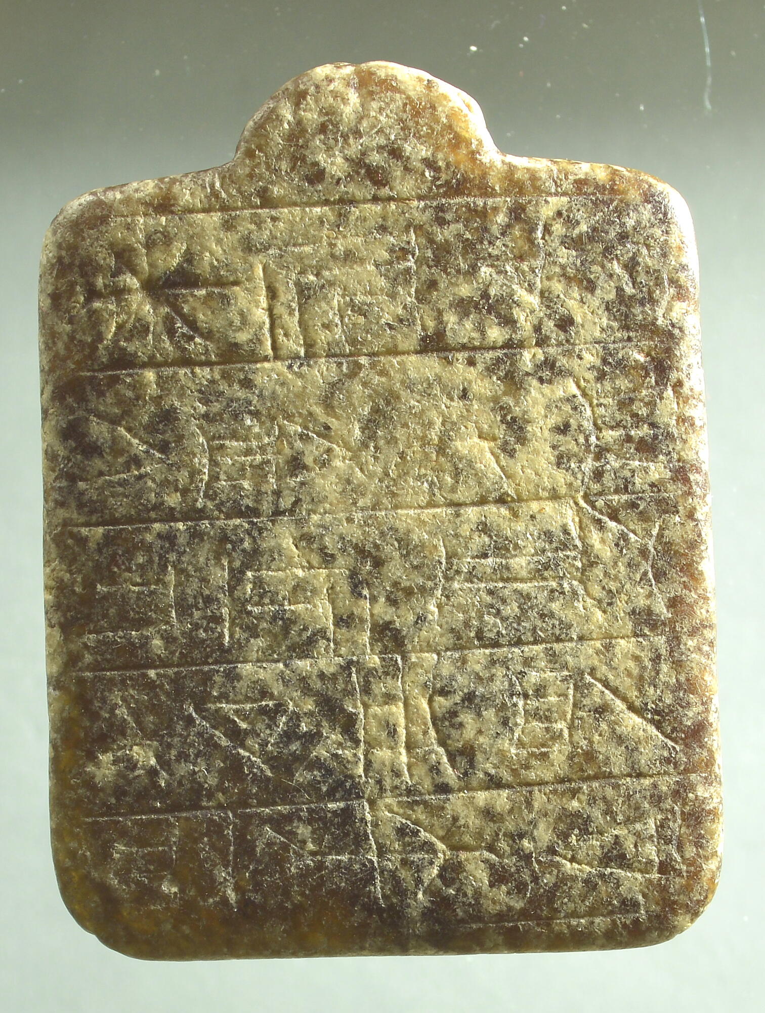 Reverse side of amulet, with worn-down incisions
