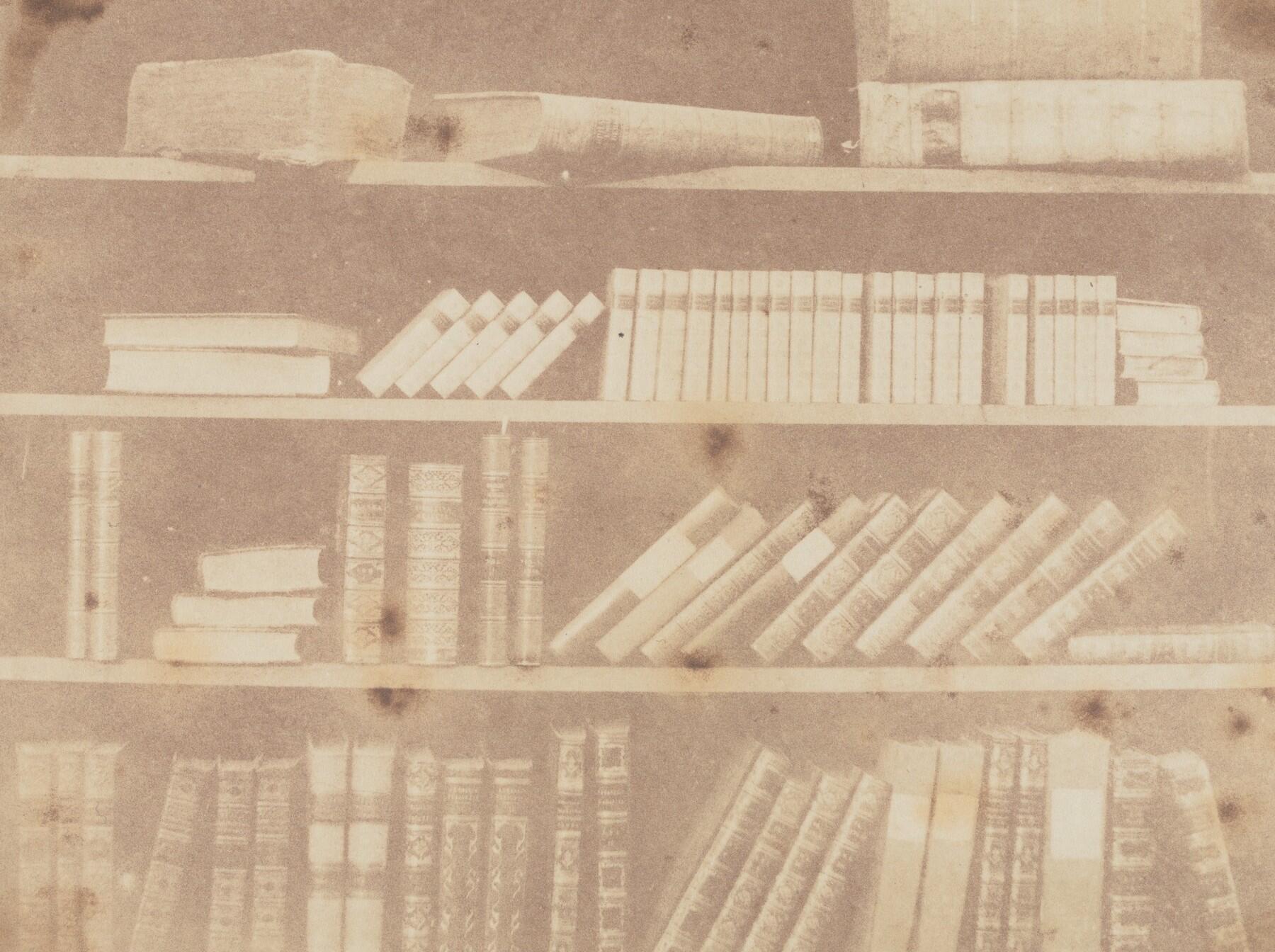 Close-up of books on four shelves, in disarray.