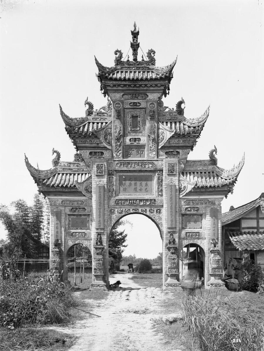 Stone memorial arch from Sichuan Province with three tiers, a central walkway in the middle, and two smaller walkways on either side.